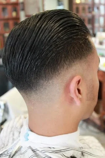 Barber chair and mirror station inside Hair We Go Again Barbershop